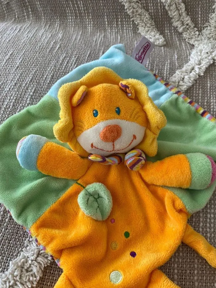 Peluche doudou plat 21cm pommette lion orange et vert très bon état - Pommette | Beebs